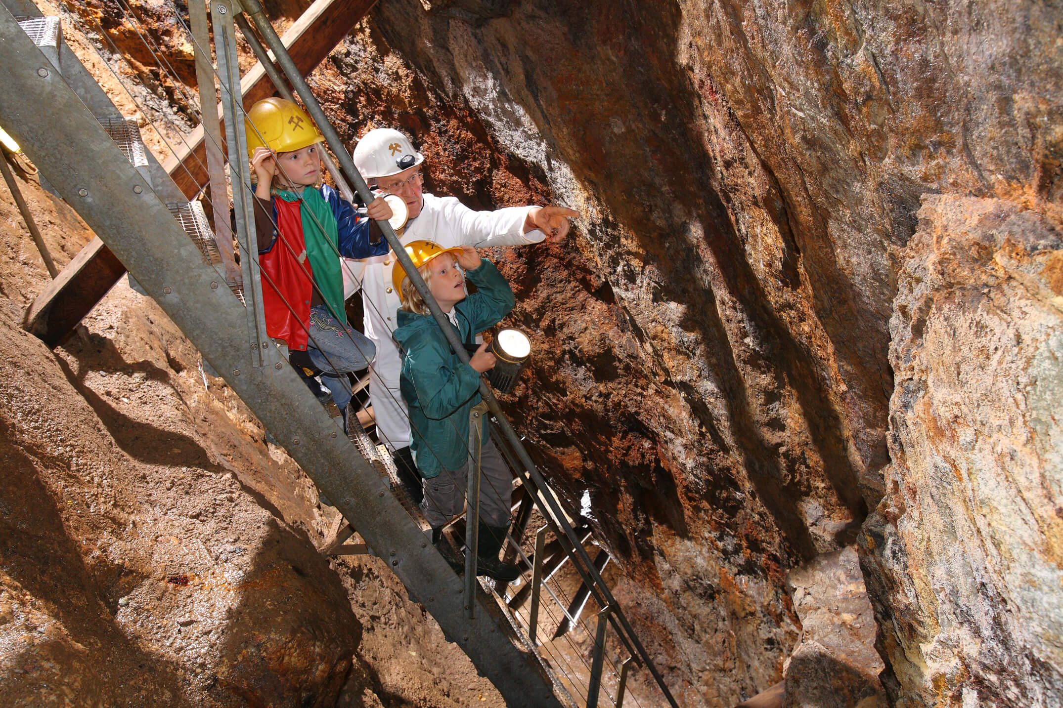 Bergwerksführer bei der Arbeit, Höhle, Bergwerk, Tropfsteine, Helm, Arbeitsjacke, Kinder