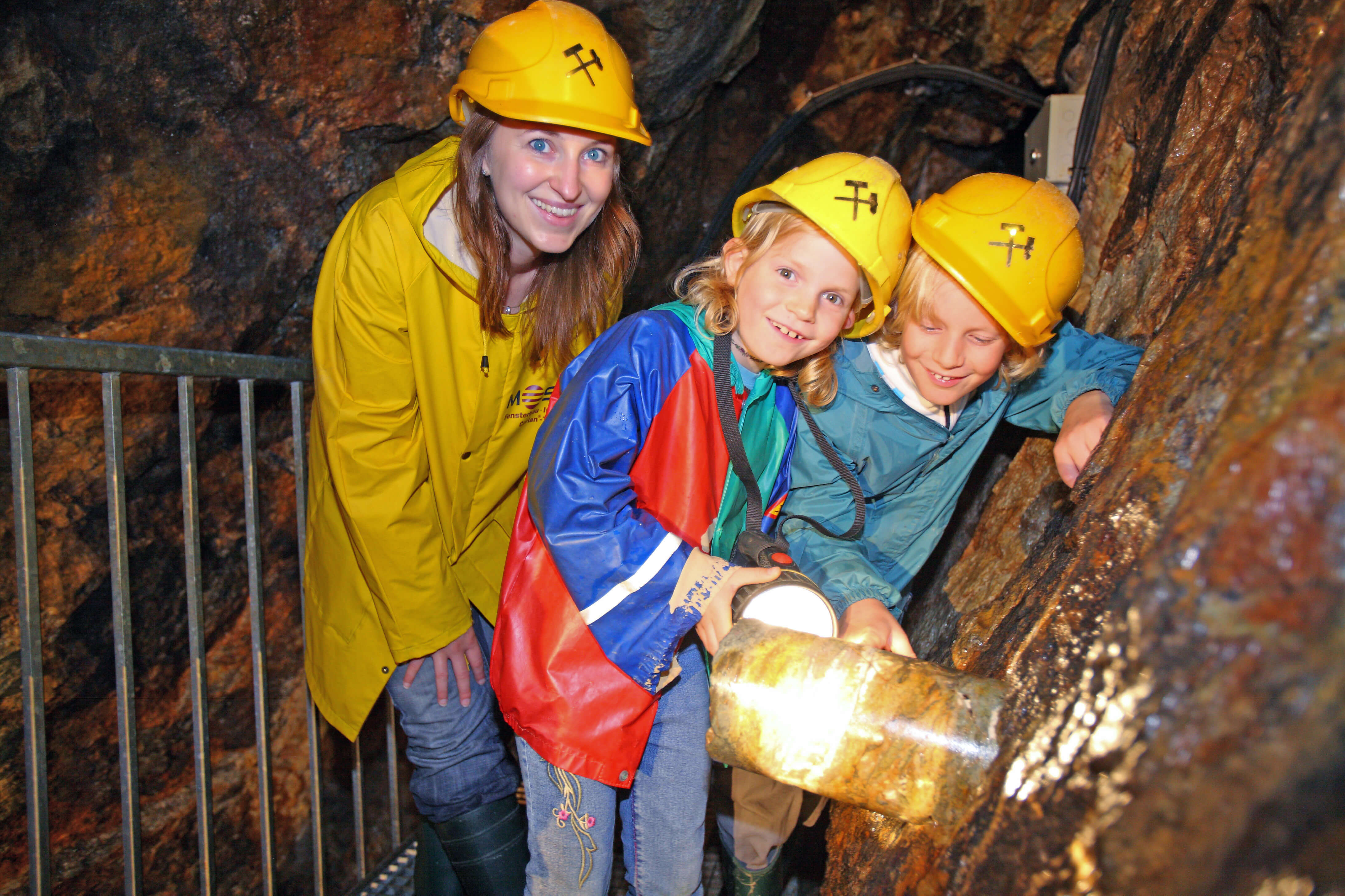 Kinder zu Beusch im Bergwerk, Bergwerksführer bei der Arbeit, Höhle, Bergwerk, Tropfsteine, Helm, Arbeitsjacke, Kinder