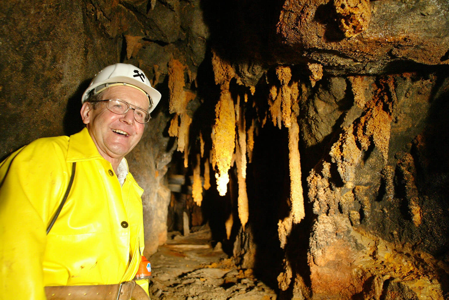 Bergwerksführer bei der Arbeit, Höhle, Bergwerk, Tropfsteine, Helm, Arbeitsjacke