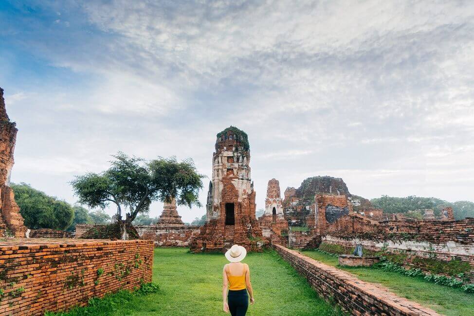 Buddhistischer Tempel in Ayutthaya mit Frau davor