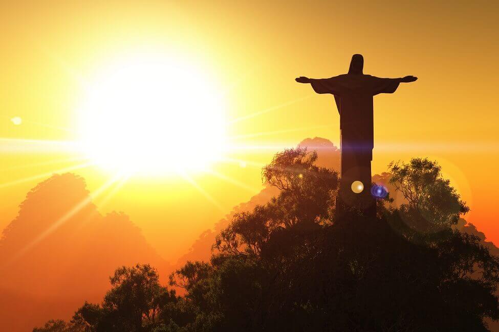 In den Abendstunden steht die Sonne hinter der Figur, die einen langen Schatten auf Rio wirft.