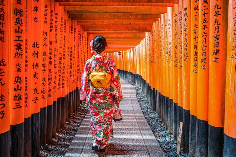 Besucherin-durschreitet-Torii-Allee-im-Fushimi-Inari-Taisha